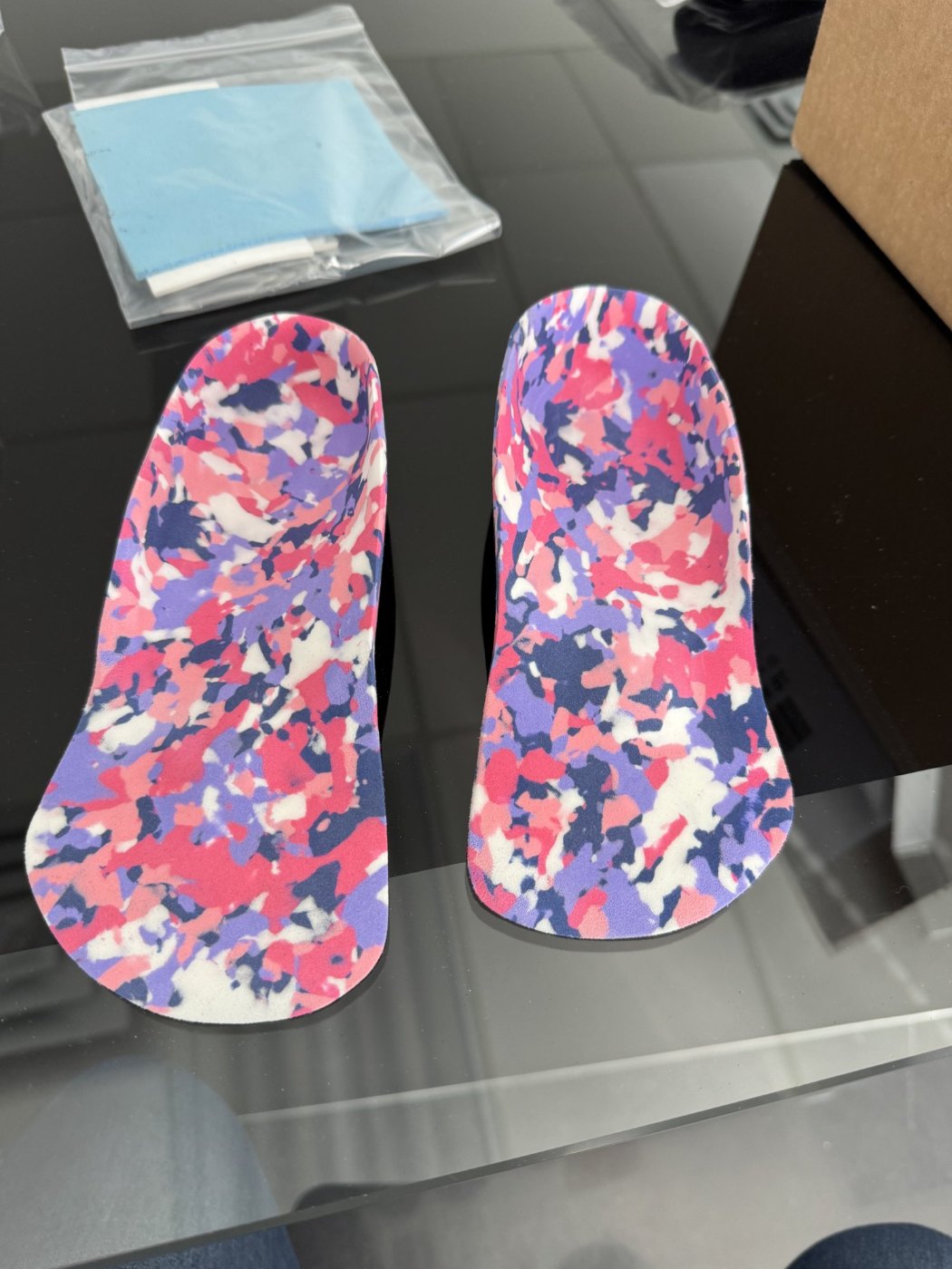 Pair of custom foot orthotics with pink and purple camo top covers