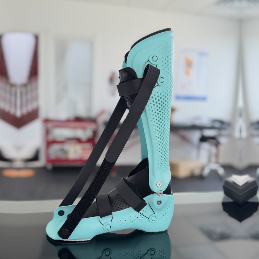 Mint blue custom night AFO with a strap that holds the foot up, made by WingTek